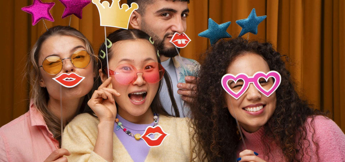 Amis posant avec des accessoires devant un photobooth